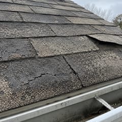 Customer photo: cracked shingles at the gutter